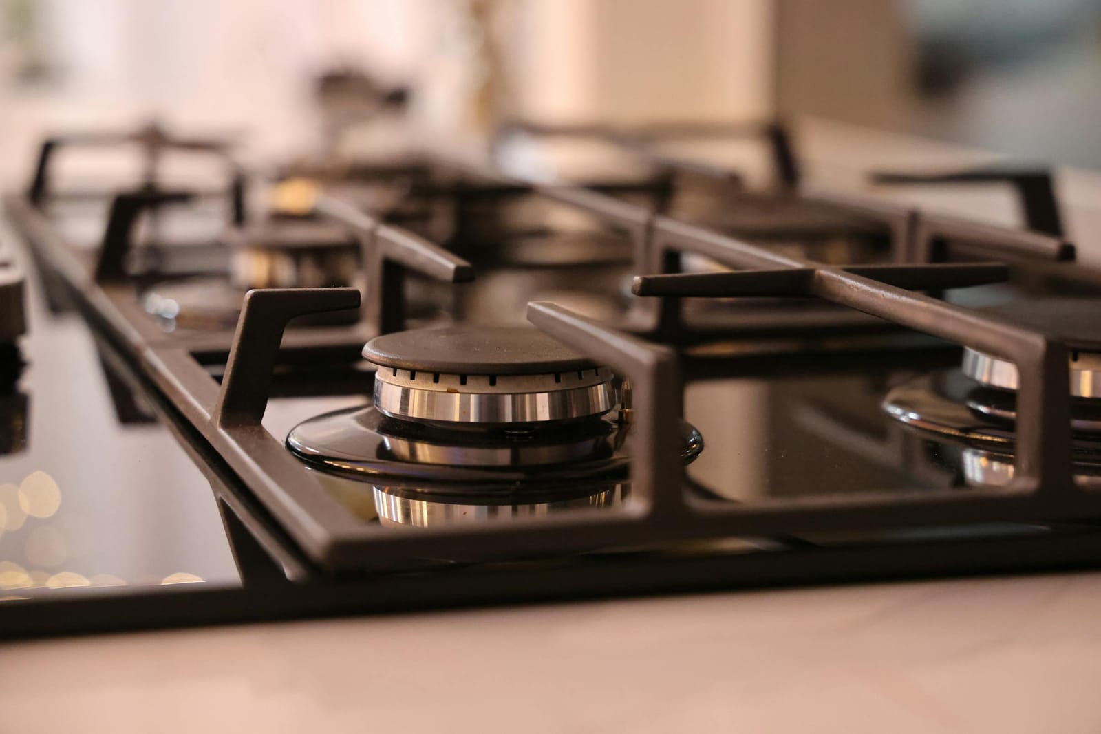 Close-up of a modern stainless steel gas cooktop with cast-iron grates