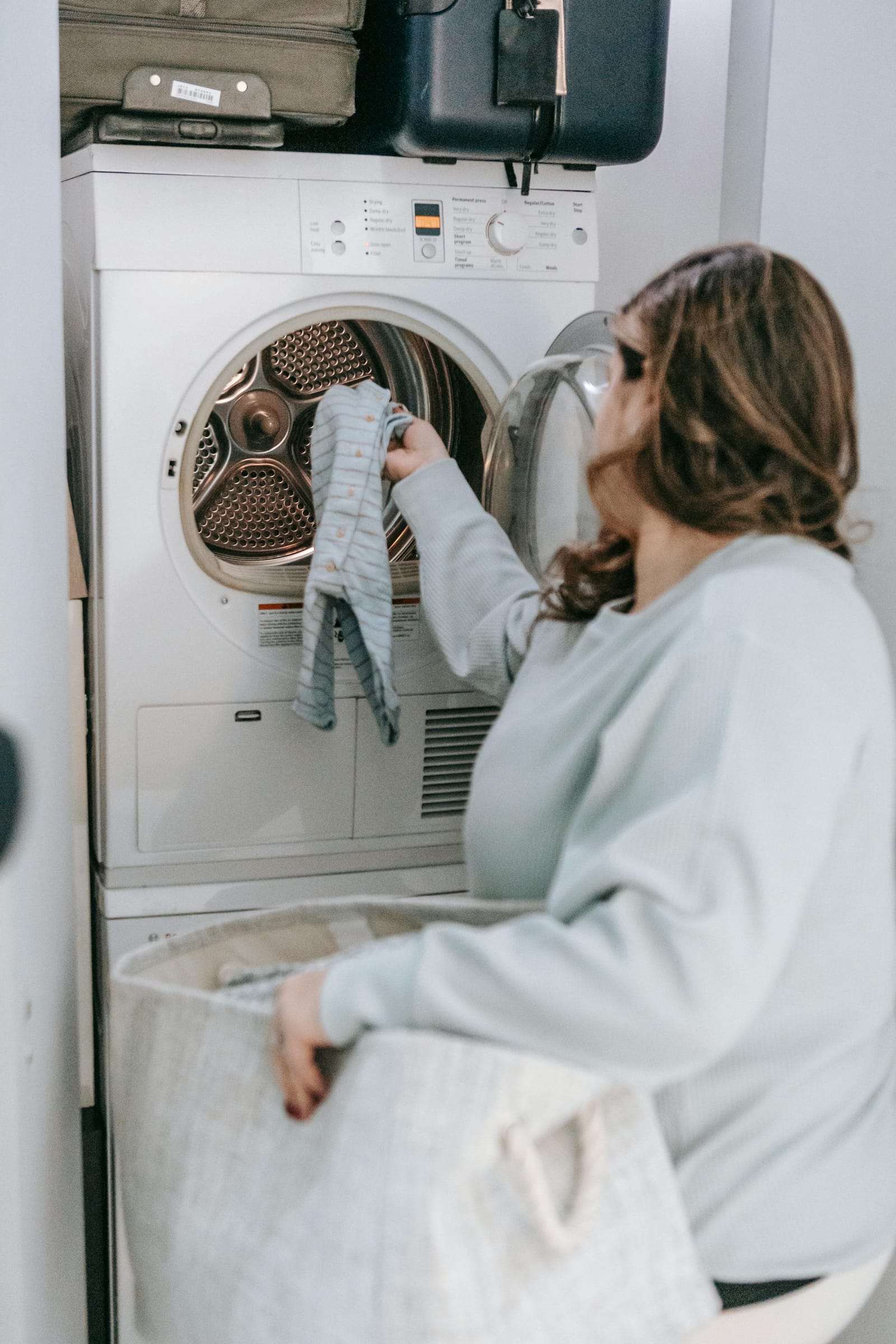 Front-loader clothes dryer with drum open showing laundry inside