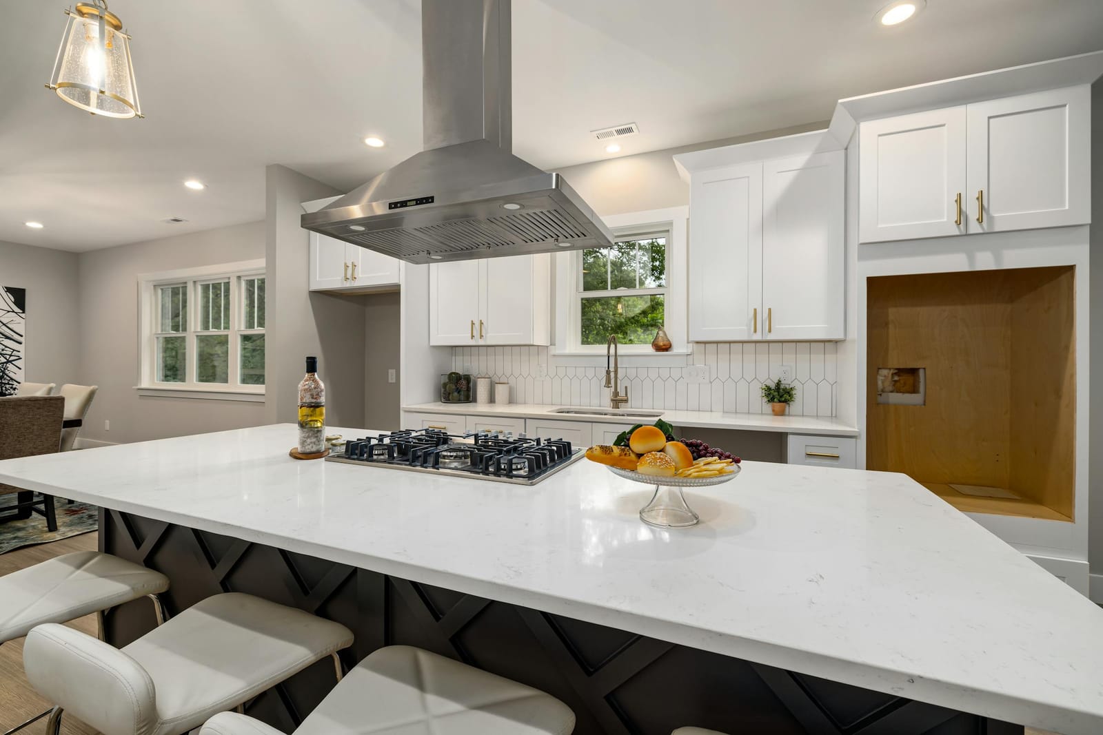 Stainless steel range hood above a gas cooktop on a kitchen island